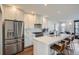 Modern kitchen with stainless steel refrigerator, white cabinets, and center island with seating, creating ideal space at 4117 Quivas St, Denver, CO 80211