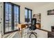 Well-lit home office with large windows, wooden desk, and shelving at 4117 Quivas St, Denver, CO 80211