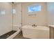 Bathroom featuring a soaking tub, shower with glass door, and a window for natural light at 2751 E 102Nd Pl, Thornton, CO 80229