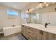 Bathroom featuring double sink vanity, soaking tub, walk-in shower, and modern fixtures at 2751 E 102Nd Pl, Thornton, CO 80229