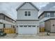 Attached two-car garage with white door, fitting seamlessly between neighboring homes at 2751 E 102Nd Pl, Thornton, CO 80229