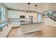 Bright kitchen features modern appliances, an island with black countertop, and pendant lighting at 2751 E 102Nd Pl, Thornton, CO 80229