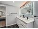 Bright bathroom boasts double vanity with white counters and illuminated mirror at 7823 S Locust Ct, Centennial, CO 80112