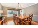 Formal dining room with hardwood floors, a large window, and a solid wood table with seating for six at 7823 S Locust Ct, Centennial, CO 80112