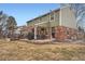 Rear exterior showcasing a covered patio, brick accents, a deck, and a spacious backyard at 7823 S Locust Ct, Centennial, CO 80112