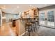 Open kitchen featuring an island with bar seating, light wood cabinets and French doors to backyard at 7823 S Locust Ct, Centennial, CO 80112