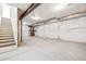 Unfinished basement with exposed ceiling beams, concrete floor, and stairs leading up to the main level at 3315 N Coolidge Way, Aurora, CO 80019