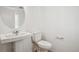 Clean half-bathroom with pedestal sink, rounded mirror, and tile flooring at 3315 N Coolidge Way, Aurora, CO 80019