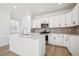 Modern kitchen featuring white cabinets, stainless steel appliances, and a center island at 3315 N Coolidge Way, Aurora, CO 80019