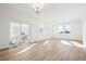 Bright living room with wood floors, white walls, multiple windows, and sliding door to patio at 3315 N Coolidge Way, Aurora, CO 80019