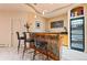 Modern bar with a unique front and stainless steel wine fridge at 6948 Fox Cir, Larkspur, CO 80118