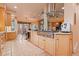 Modern kitchen with stainless steel appliances, wood cabinetry, and tile flooring at 6948 Fox Cir, Larkspur, CO 80118