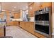 Bright kitchen featuring stainless steel appliances, tile floors, and light wood cabinetry at 6948 Fox Cir, Larkspur, CO 80118