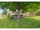 Private backyard with mature trees, lush lawn, and an elevated deck for relaxing or entertaining guests outdoors at 13753 Monroe St, Thornton, CO 80602