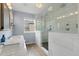 This bathroom features a glass shower, double sinks, and wood-look tile flooring at 13753 Monroe St, Thornton, CO 80602