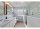 This bathroom features a glass shower, double sinks, and wood-look tile flooring at 13753 Monroe St, Thornton, CO 80602