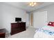 This bedroom features carpet flooring, a ceiling fan, and a large dresser with a TV on top at 13753 Monroe St, Thornton, CO 80602