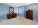 This bedroom features blue walls, carpet flooring, and two dressers with mirrors at 13753 Monroe St, Thornton, CO 80602