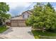 Charming two-story home with a three-car garage, lush lawn, mature trees, and a welcoming driveway at 13753 Monroe St, Thornton, CO 80602