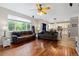 Comfortable living room featuring hardwood floors, a large window overlooking the backyard, and a partial view of the kitchen at 13753 Monroe St, Thornton, CO 80602
