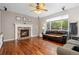 Cozy living room features hardwood floors, a brick fireplace, and ample natural light from the backyard at 13753 Monroe St, Thornton, CO 80602