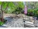 A peaceful outdoor space featuring a stone patio, lush landscaping, and a shaded seating area at 787 Eldorado Dr, Superior, CO 80027