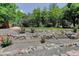 Beautifully landscaped backyard with stone walls, mature trees and a lush lawn offering a serene outdoor retreat at 787 Eldorado Dr, Superior, CO 80027