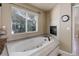 Bathroom featuring tile surround soaking tub with fireplace and large window at 787 Eldorado Dr, Superior, CO 80027