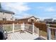 A quaint back deck with white railings overlooks the fenced backyard at 481 Vista Blvd, Brighton, CO 80603