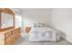 Bright bedroom featuring a dresser, nightstand, and a cozy bed with a patterned quilt at 481 Vista Blvd, Brighton, CO 80603