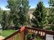 Relaxing backyard view from a wooden deck overlooking the grassy lawn with mature trees and white picket fence at 3966 Aspen Hollow Ct, Castle Rock, CO 80104