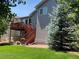 A home's backyard features a two-story deck and stairway, green lawn, landscaping and mature trees at 3966 Aspen Hollow Ct, Castle Rock, CO 80104