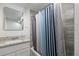 Bathroom with granite countertop, striped shower curtain, and bathtub at 1901 Clinton St, Aurora, CO 80010