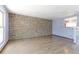 An empty living room featuring hardwood floors, stone wall accent and a pass-through bar to the kitchen at 10926 Dahlia Way, Thornton, CO 80233