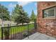 Apartment balcony overlooks landscaped lawn with mature shade trees at 3701 Arapahoe Ave # 106, Boulder, CO 80303