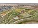 Overhead view of a large community park with walking paths, playgrounds, and open green spaces at 21440 E 61St Dr, Aurora, CO 80019
