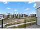 Balcony view showcasing a modern community with walking paths and green spaces at 21440 E 61St Dr, Aurora, CO 80019