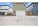 Two-car garage with an exterior of green siding and a large concrete driveway at 21440 E 61St Dr, Aurora, CO 80019