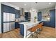 Modern kitchen features a large island with seating, navy cabinets, and stainless steel appliances at 21440 E 61St Dr, Aurora, CO 80019