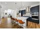 Modern kitchen boasts navy cabinets, a waterfall island with seating, and a decorative backsplash at 21440 E 61St Dr, Aurora, CO 80019