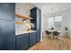 Bright kitchen features custom navy cabinets, open shelving, and decorative tile backsplash at 21440 E 61St Dr, Aurora, CO 80019