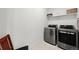 A functional laundry room equipped with modern stainless steel washer and dryer units at 21440 E 61St Dr, Aurora, CO 80019