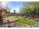 Lush backyard with green grass, mature trees and patio seating area at 10801 W 29Th Ave, Lakewood, CO 80215