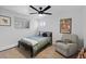 This cozy bedroom features a ceiling fan, a sitting area with a chair, and a calming, neutral color palette at 10801 W 29Th Ave, Lakewood, CO 80215