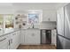 Modern kitchen boasts white cabinets, stainless steel appliances, and hardwood floors at 10801 W 29Th Ave, Lakewood, CO 80215