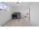 Bright laundry room features a modern washer and dryer, beautiful floor tiling and a window with natural light at 10801 W 29Th Ave, Lakewood, CO 80215