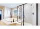 Bathroom with a soaking tub, glass shower, and neutral tile at 6051 E 160Th Pl, Brighton, CO 80602