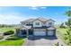 Beautiful two-story home featuring a three-car garage, stone accents, and manicured landscaping at 6051 E 160Th Pl, Brighton, CO 80602