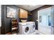 Laundry room with washer, dryer, and storage cabinets with dark walls at 6051 E 160Th Pl, Brighton, CO 80602