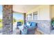 Covered patio with stone columns, seating area, and outdoor view at 6051 E 160Th Pl, Brighton, CO 80602